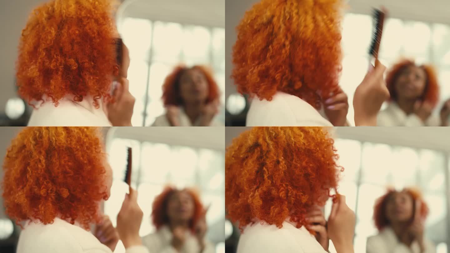 年轻女子在镜子前梳理红色卷发，增加头发的蓬松度