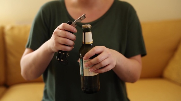 一段4k视频，记录了一个面目全非的女人在家里打开啤酒瓶
