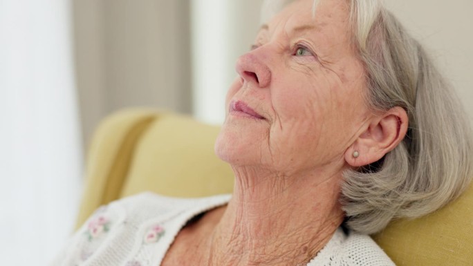 老年妇女，在家里的沙发上面对和思考，回忆悲伤的记忆，放松退休。患有精神健康、情绪或阿尔茨海默病的在护