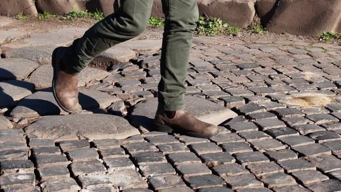 走在古罗马铺路石和鹅卵石上。走的脚。
