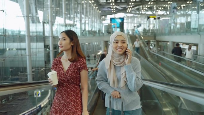 这名亚洲女游客正在机场乘坐自动扶梯前往国际航班的检票处。