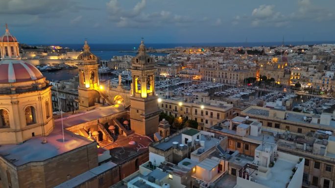 航拍傍晚的马耳他。在圣格利亚的教堂周围飞行，在马耳他的游艇码头欣赏三个城市的景色