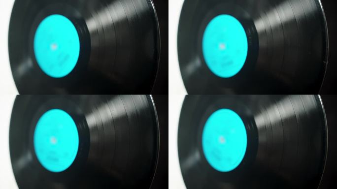 黑胶唱片，蓝色标签在黑白背景上旋转，选择性聚焦。