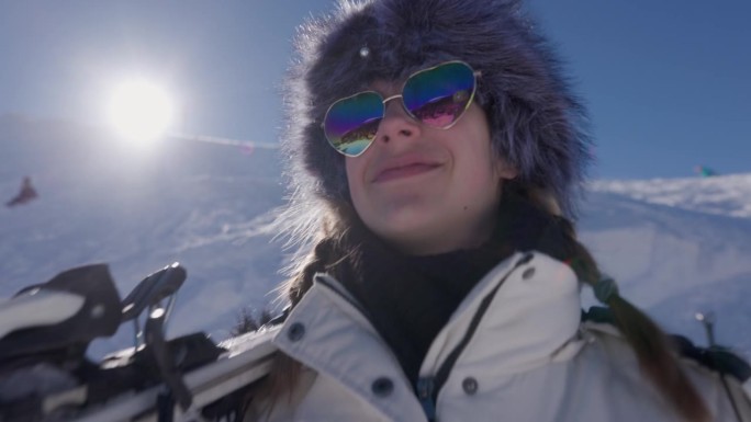 一个酷酷的年轻女子在高山滑雪胜地拿着她的滑雪板的肖像