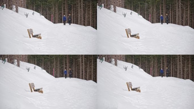 一对游客夫妇在冬季暴风雪中经过奥地利阿尔卑斯山的徒步旅行路线标记杆