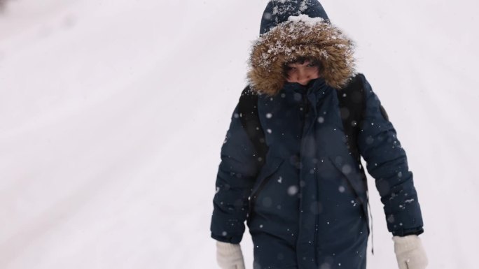 快乐的小男孩在上学的路上玩雪