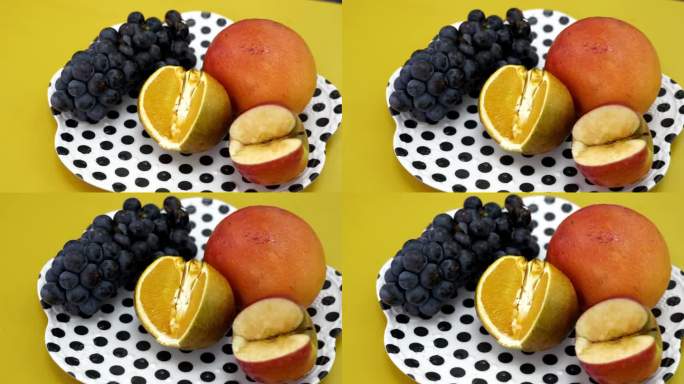 盘子里的水果有芒果、橘子、苹果和浆果