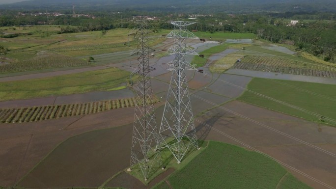 无人机拍摄的稻田中央的高压塔。印尼用于向村庄配电的电塔。