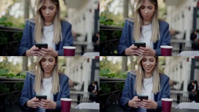 年轻女子在街边咖啡馆用智能手机聊天，桌上放着一杯咖啡