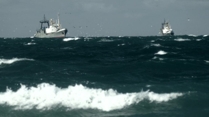 拖网渔船在狂风暴雨的冬季海上捕鱼
