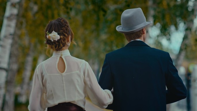 一对身着19世纪礼服的已婚夫妇在秋天漫步在公园里，后视图，4K, Prores