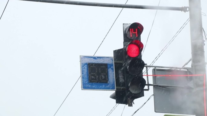 在乌克兰冬天的白天，道路上的交通灯和降雪，从汽车上看，冬天和道路