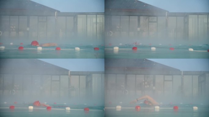 侧视图坚定的女游泳运动员练习自由泳在雾蒙蒙的游泳池在豪华旅游胜地
