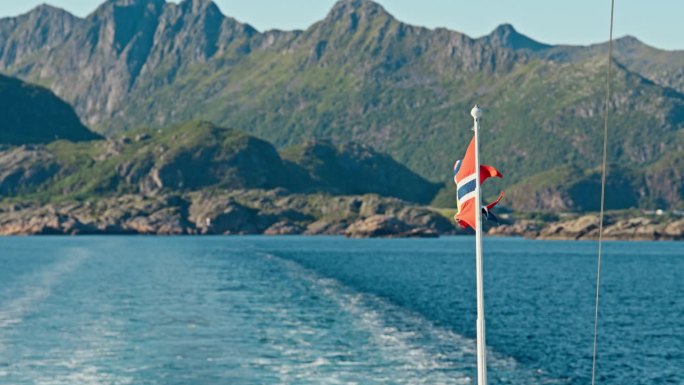 挪威的邮政旗帜在一艘渡轮上对着山的背景