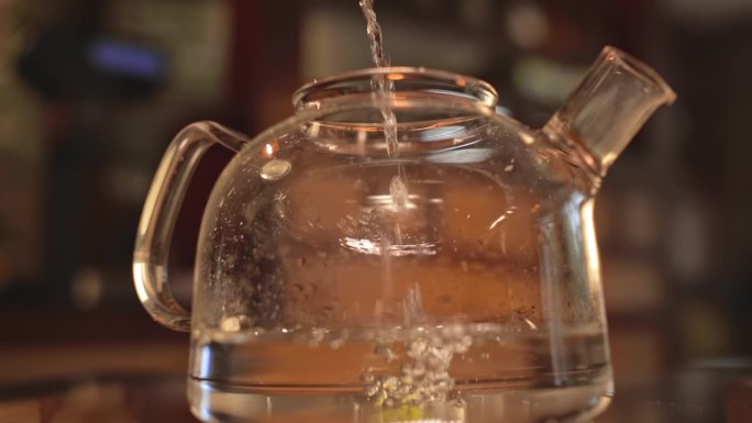 一股水流进了一个透明的大茶壶