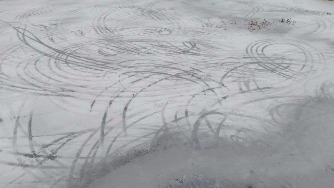冬天把淹水的田地变成了冰。一架无人机捕捉到冰面上漂移的汽车留下的错综复杂的汽车轨迹