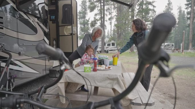多代同堂的家庭在户外露营地吃早餐