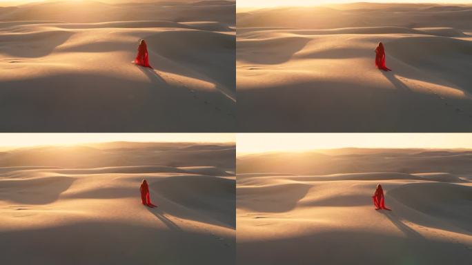 日出时，穿红袍子的女人走在沙丘上