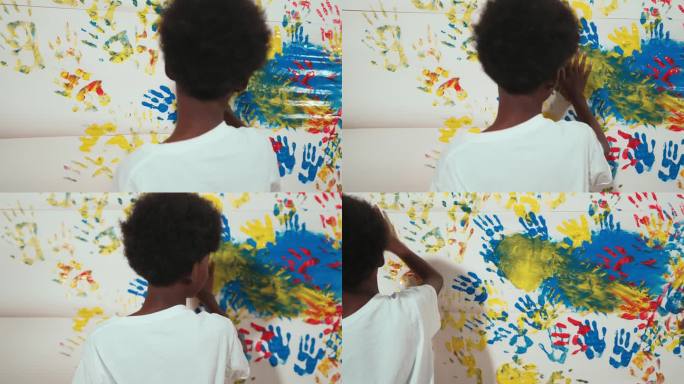 快乐的非洲男孩的后景，用手画着污迹斑斑的墙壁。启迪