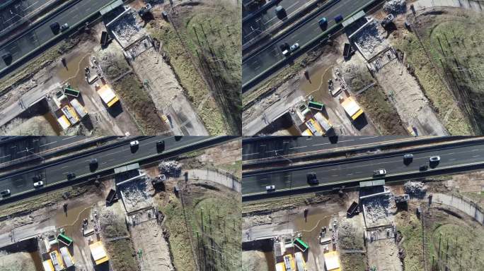 无人机拍摄的高速公路旁的一个建筑工地，你可以看到机器和人在高速公路上行驶。