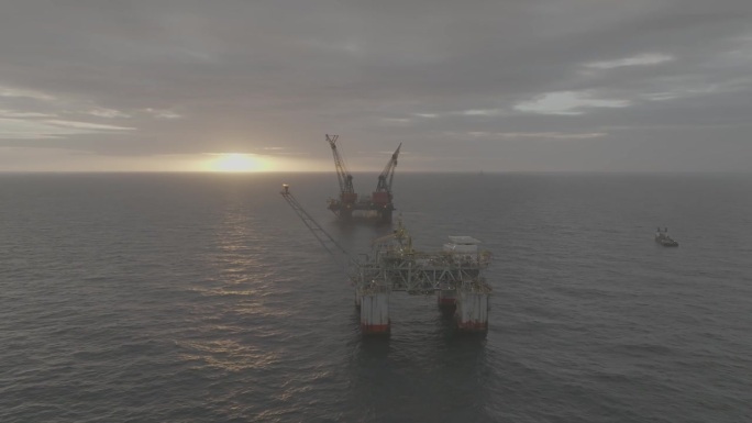 两个石油钻井平台在日出和日落时的无人机镜头。