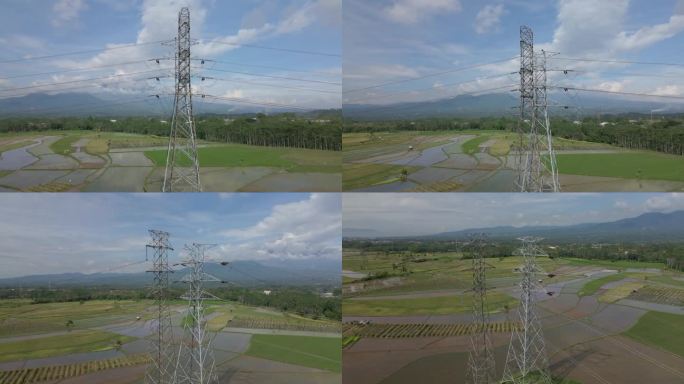 螺旋无人机拍摄的建在稻田种植中心的高压电力塔。印度尼西亚农村地区的配电设施。