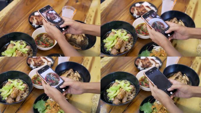 亚洲女性网红在泰国餐厅用智能手机拍摄食物。