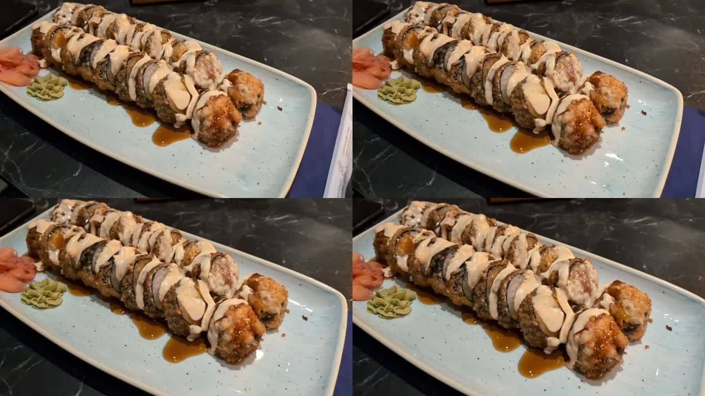 美味的日本金枪鱼真木卷配芥末和奶油酱，在餐厅的盘子里。