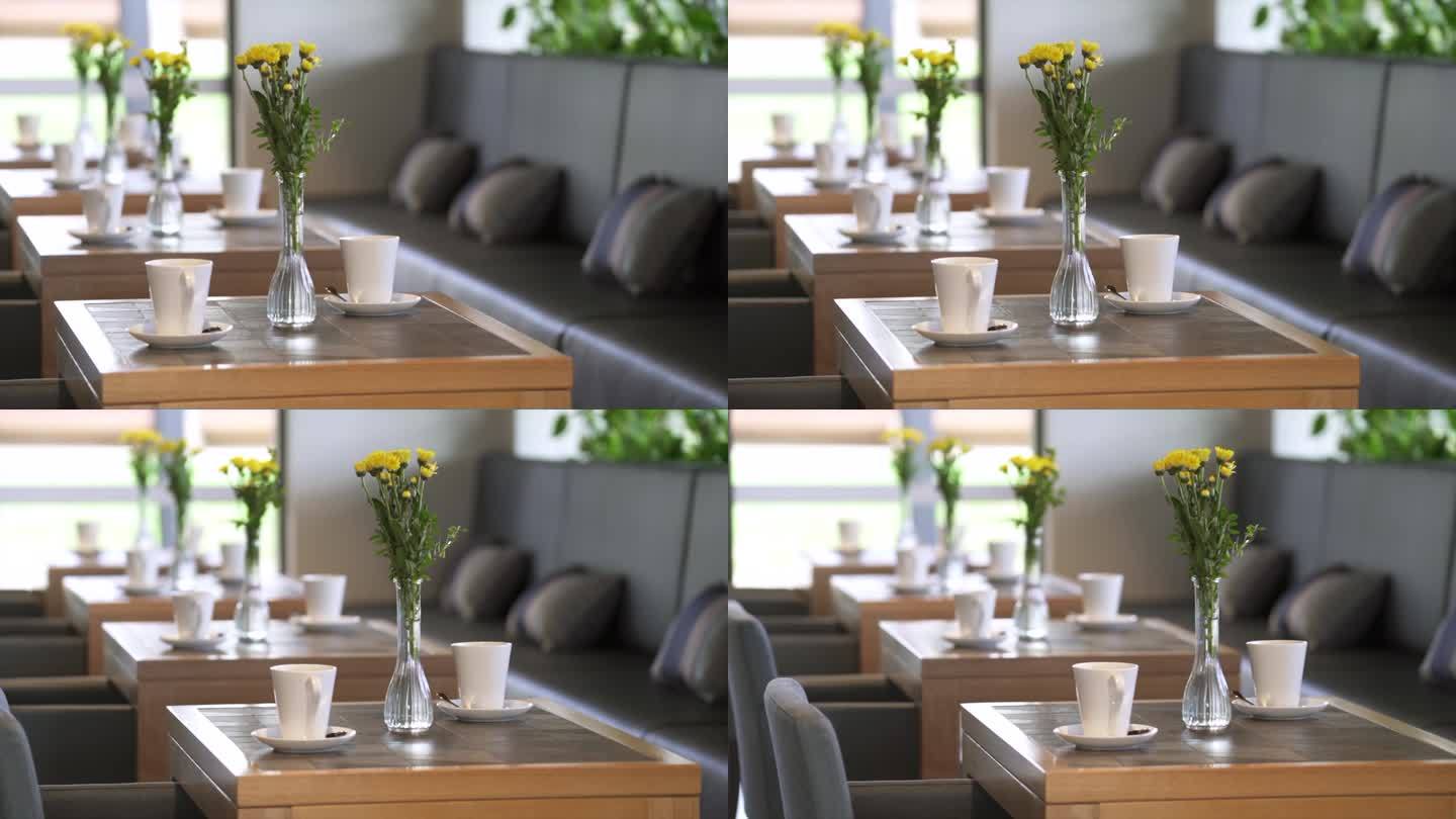 在现代时尚的咖啡馆和餐厅里，餐桌上的鲜花花瓶和咖啡杯
