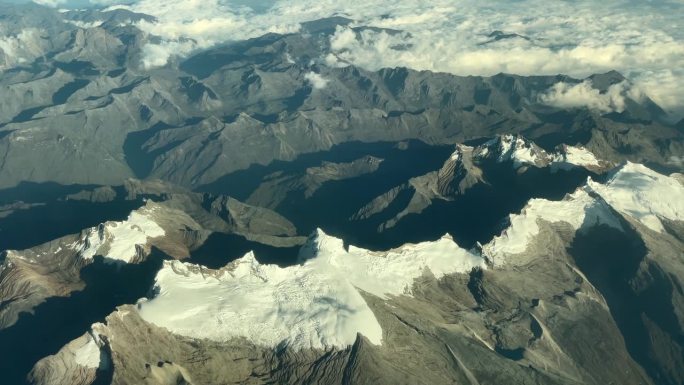 鸟瞰图，干旱的山顶上有雪。从空中俯瞰雪山。无人机。