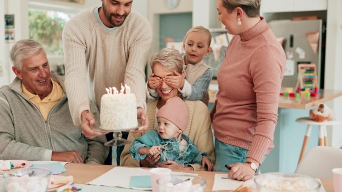 惊喜，生日和老年妇女与家人庆祝，乐趣和纽带在他们的家在一起。蛋糕，蜡烛和祖母和孩子们在一个房子里聚会
