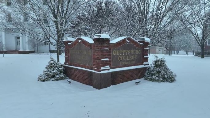 宾夕法尼亚州葛底斯堡学院的砖招牌。雪落在美国大学校园里。学术界的主题。