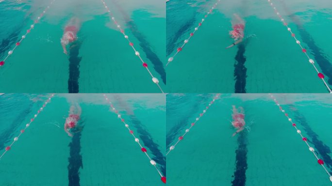 在户外度假胜地绿松石泳池游泳的坚定年轻女子的高角度跟踪拍摄