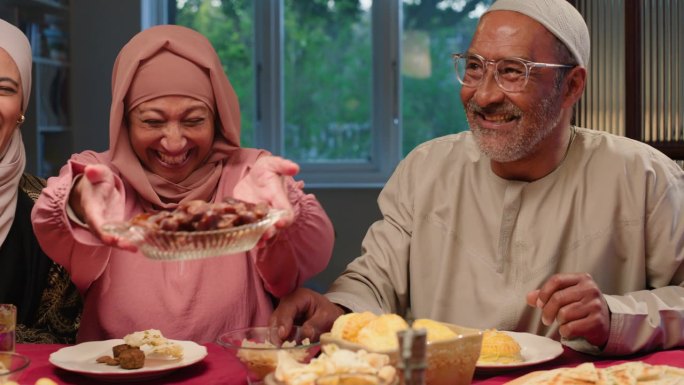 快乐的家庭，欢笑或伊斯兰教的斋月食物分享膳食，营养或宗教节日在家里的桌子。穆斯林人，传统或斋月由清真