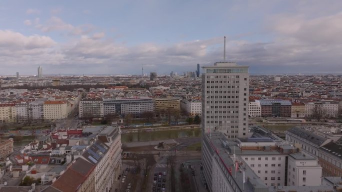 前锋在市区的建筑物上空飞行。河岸上的旧高层办公楼。奥地利的维也纳