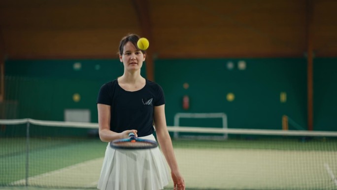 体育俱乐部里微笑的年轻女运动员在拍子上跳网球