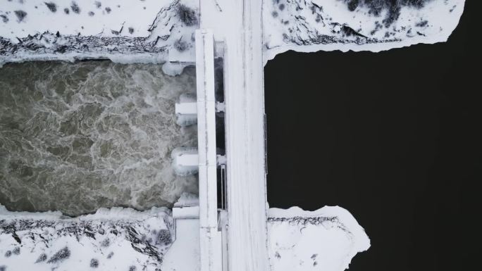 近距离缓慢建立拍摄航拍无人机视图湍急的水Notigi水电大坝河雪景北部冬季马尼托巴省加拿大