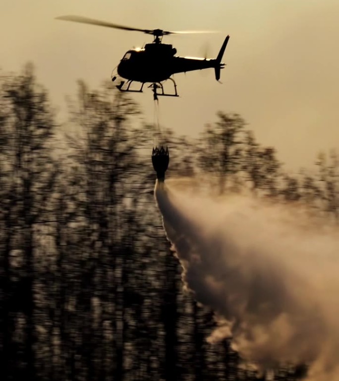 消防直升机在野火上洒水