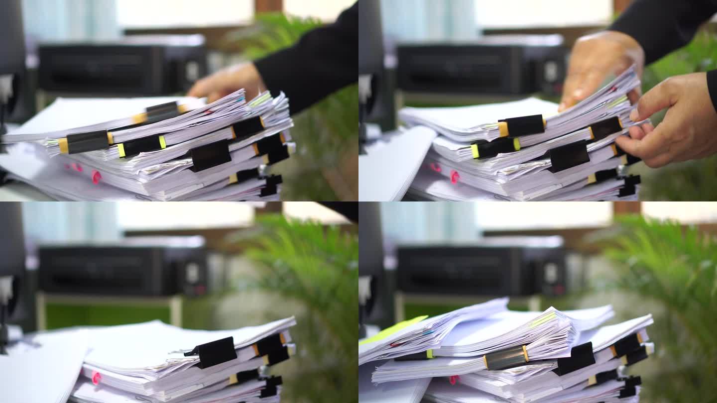未完成的报告文件文件夹用黑色的夹子。在办公室的桌子上堆放大量的协议报告单，准备管理员的签字或批准