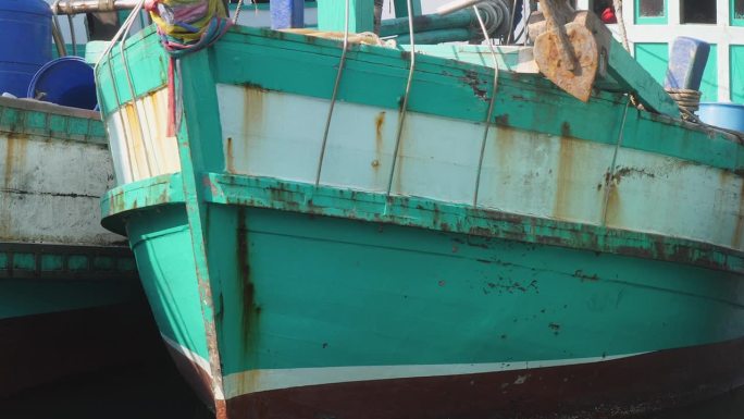 一艘木制渔船离开拥挤的港口时船头的特写镜头