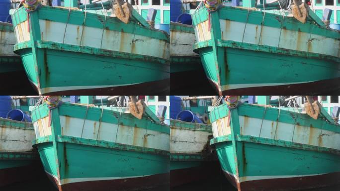 一艘木制渔船离开拥挤的港口时船头的特写镜头