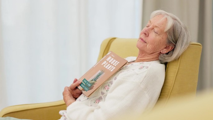 放松，书和老年妇女睡在她的现代住宅的客厅在一个周末。平静、平和的退休女性在家里看完故事或小说后打盹。