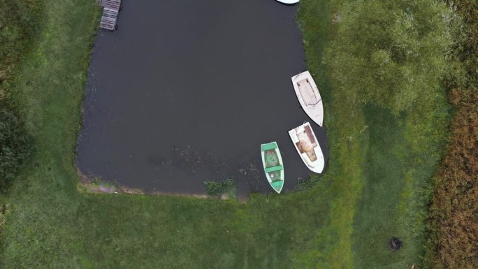 三艘旧船被遗弃在湖岸，无人驾驶飞机降落
