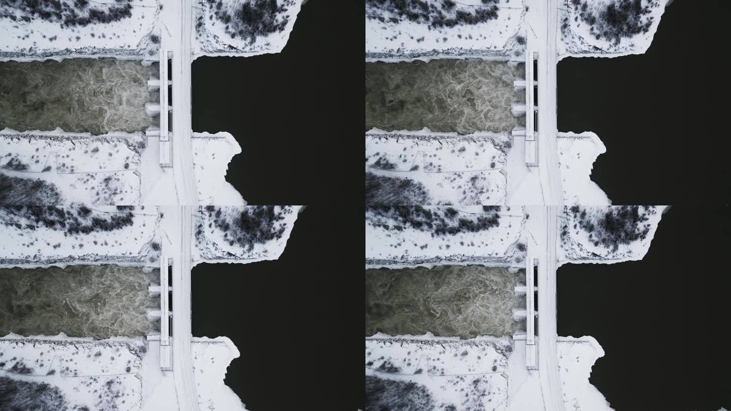 缓慢建立拍摄空中无人机视图湍急的水Notigi水电站，河流湖泊雪景北部冬季马尼托巴省加拿大
