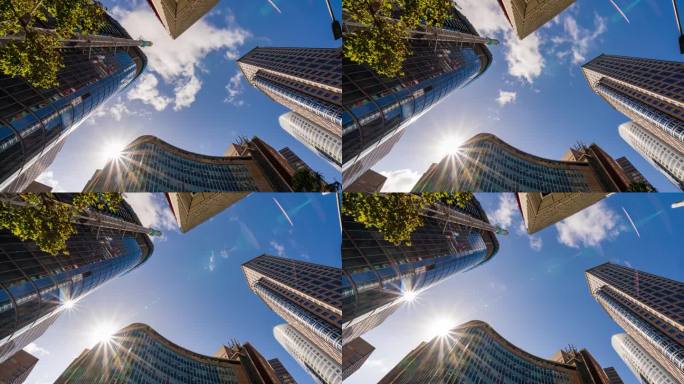 澳大利亚悉尼中央商务区高楼大厦中心，云层和太阳反射的摩天大楼低角度