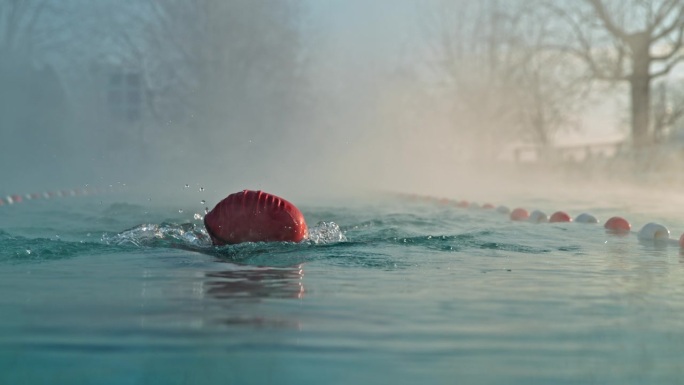 运动女子在度假胜地雾蒙蒙的游泳池游泳的超级慢动作锁定镜头