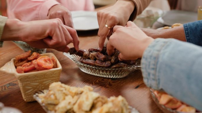 手，分享或伊斯兰教在斋月与食物，膳食营养或爱与宗教节日在家里的餐桌。穆斯林人，文化和开斋与清真美食一