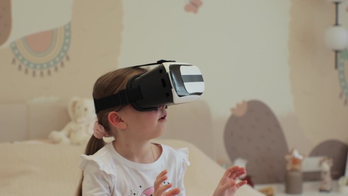 小女孩戴着虚拟现实耳机与数字世界互动，好奇的孩子用虚拟现实探索宇宙，坐在家里的床上。