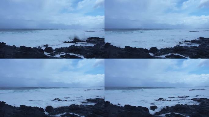 海浪滚滚，翻滚白沫浪花拍打黑礁石