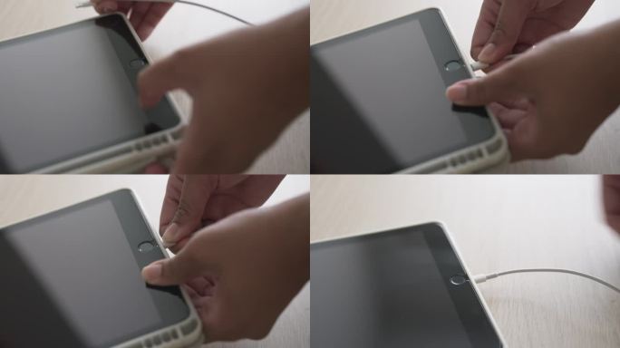 用手把数码平板电脑的充电电池线插在桌上